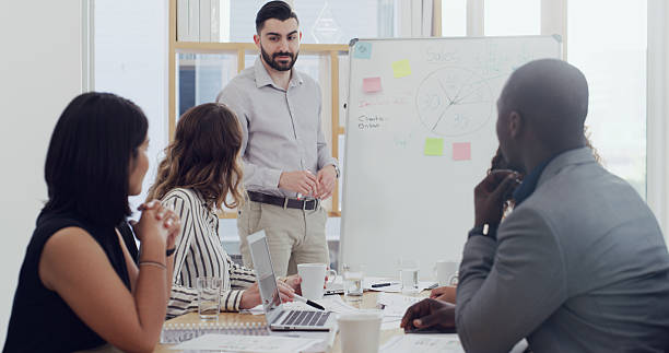 istock Whiteboard, presenter or businessman with team for graphs, sales performance or analysis. Group, presentation or talk in meeting with chart for training, strategy or financial stats for KPI in office 2232147232