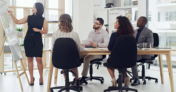 istock Presentation, board and teaching with business people in meeting for planning, discussion or sales projection. Profit review, team and speaker with employees in office for revenue growth and pitch 2232147236