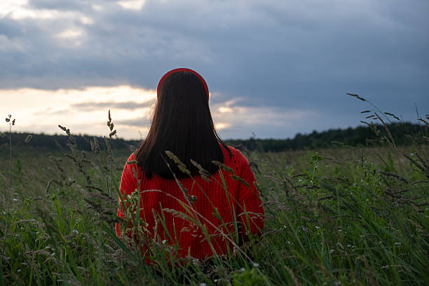istock Woman in Red Sweater in Grassy Field 2232149480