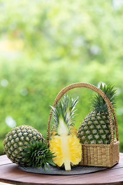 Pineapple in basket on green nature background, Pineapple tropical fruit on wooden table.