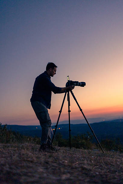 istock Photographer Capturing Beautiful Twilight Scenery with Professional Camera Setup 2232151006