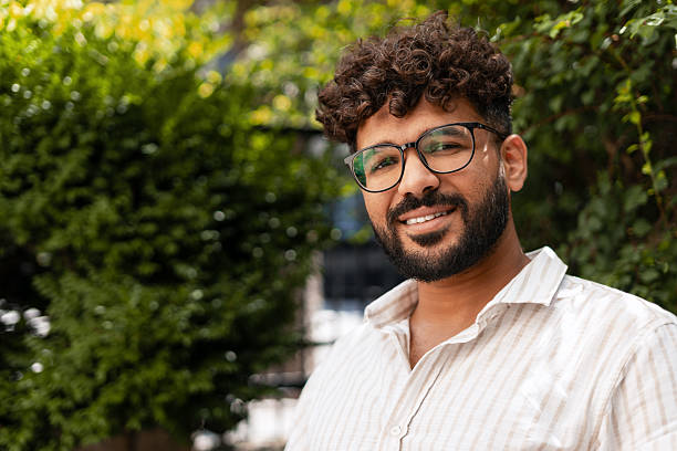 istock Young Indian Man Smiling Outdoors in a Green Park 2232151702
