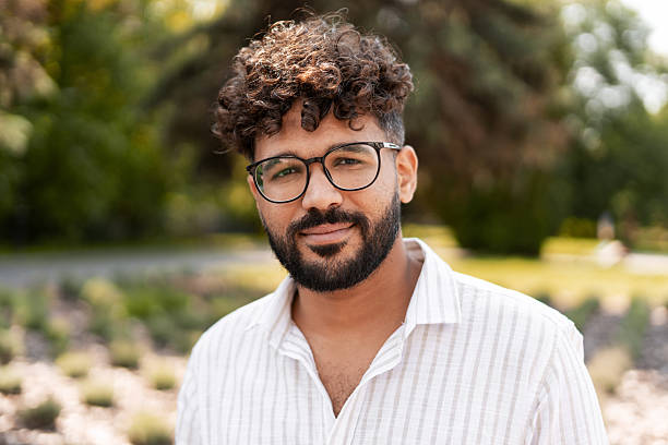 istock Young Man Smiling and Wearing Glasses in a Park 2232153648