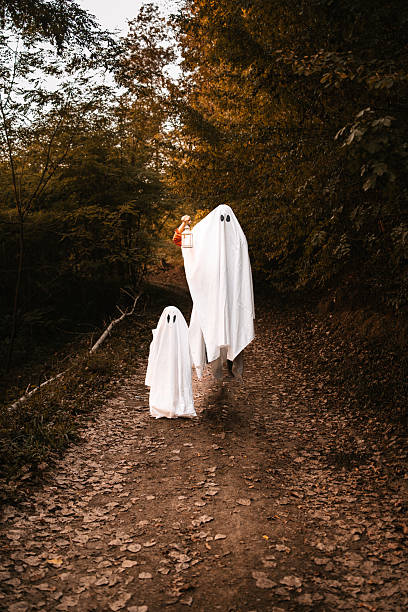 istock Flying Halloween Ghosts with Lantern in Autumn Forest 2232153939