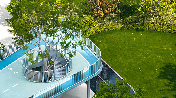 istock Elevated walkway and tree planter in green apartment landscape garden 2232154163