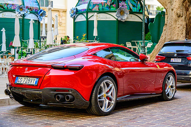 Ferrari Roma (Type F169) grand touring car parked on the street in front of Hotel Hermitage in Monte Carlo. The Roma has a front mid-engine, rear-wheel-drive layout with a twin turbocharged V8 engine and a 2+2 seating arrangement. The design was influenced by the classic Ferrari 250 GT Lusso and 250 GT 2+2 grand touring cars of the 1960s.
