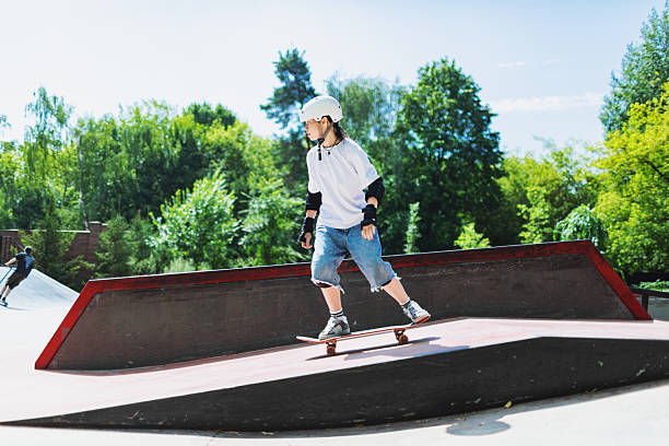 istock Schoolage girl skateboarding at skateboard park 2232156151