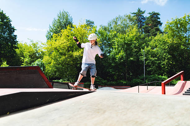 istock Schoolage girl skateboarding at skateboard park 2232156209