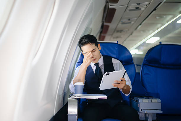 istock Tired businessman feeling stressed in first class during a work trip. Captures the concept of business travel pressure, fatigue, and corporate burnout in aviation settings. 2232158657