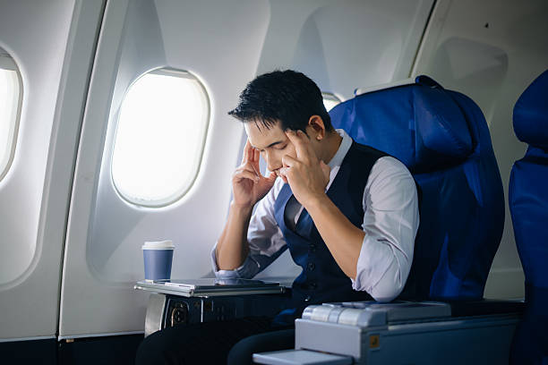 istock Tired businessman feeling stressed in first class during a work trip. Captures the concept of business travel pressure, fatigue, and corporate burnout in aviation settings. 2232158658