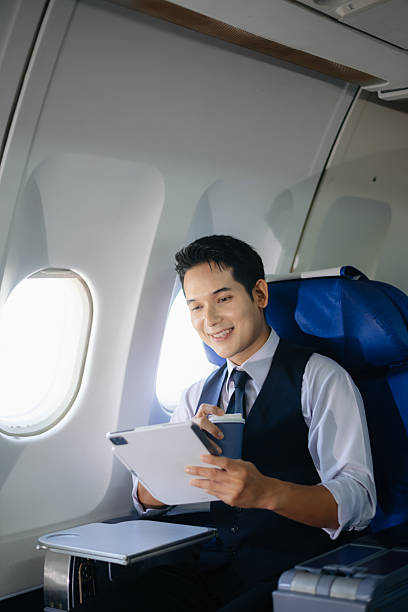 istock Young businessman working on a tablet while enjoying coffee in first class. Perfect image for travel, corporate lifestyle, and modern technology themes. 2232158666