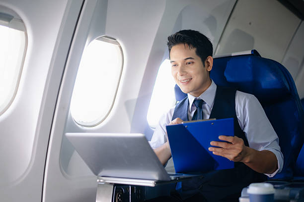 istock Businessman working on a laptop with documents during a first-class flight. Perfect for themes of productivity, corporate travel, and global business success. 2232158678
