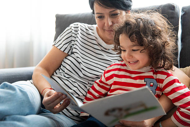 istock Kid Reading Children's Book with Mom 2232159339