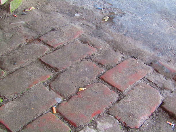 istock Weathered red brick path with dirt gaps and outdoor ground texture for rustic outdoor scene 2232160092