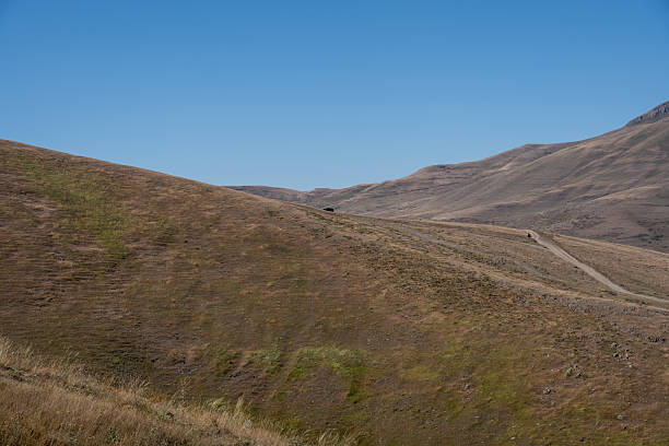 istock Vehicles on Remote Road in Rugged Highland Terrain and Dry Farming Fields 2232160431