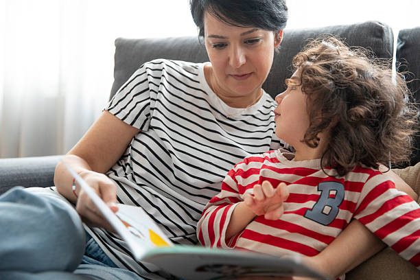 istock Kid Reading Children's Book with Mom 2232160650