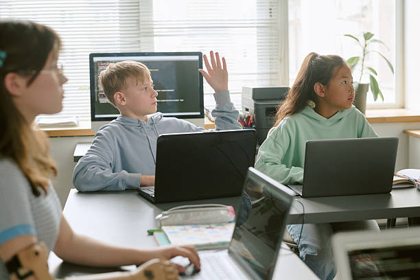 istock Teenage Caucasian Boy Raising Hand While Studying with Diverse Classmates 2232160807