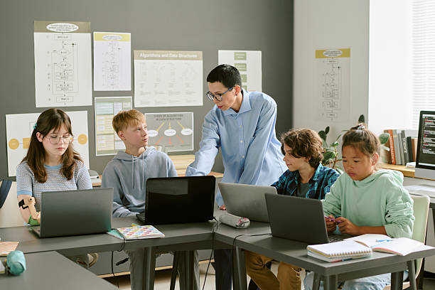 istock Teacher Instructing Diverse Teenagers Using Laptops in Classroom 2232161533