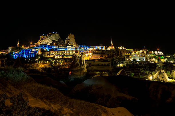 Uchisar Castle and the town in Cappadocia, Turkey, illuminated at night within the UNESCO World Heritage landscape.
