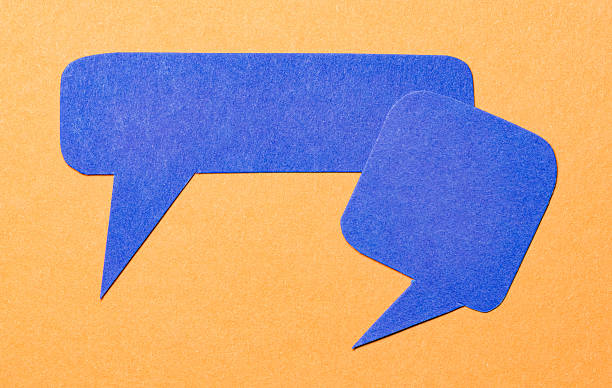istock Blue blank cut out paper speech bubbles with copy space for text on orange background, flat lay top view conversation backdrop 2232163725