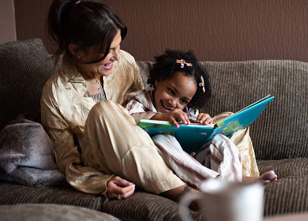 istock Affectionate mother reading book with adorable toddler daughter. 2232164271