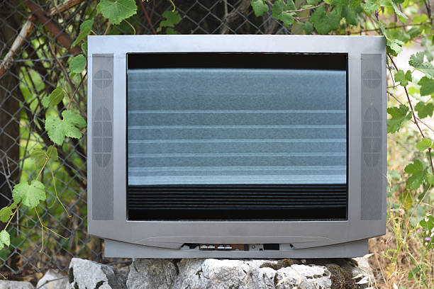 istock An old television with noise and interference on the screen, abandoned in nature near a wire fence during the day. 2232167366