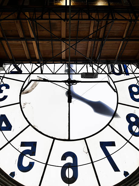 Quito, Pichincha, Ecuador - April 15, 2025: Clock face and mechanism of the Quito's main square clock tower, showing its intricate details and the shadow of the clock hands projected onto the white surface