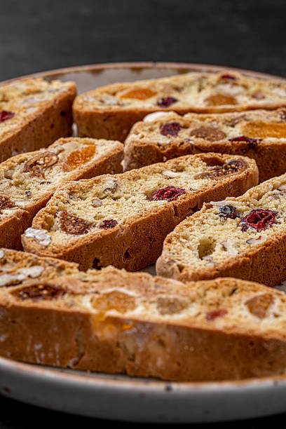 istock Italian Almond Biscotti biscuits in a rustic home made pottery bowl. Studded with almonds and cranberries, these twice-baked treats are aromatic and inviting. Ideal. 2232169469