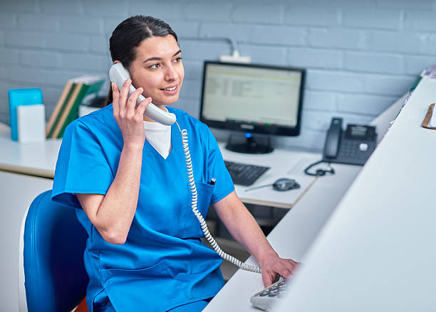 istock Medical Receptionist Taking a Phone Call at Front Desk 2232170025