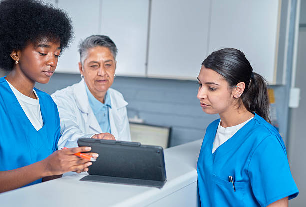 istock Medical Team Collaborating at Front Desk with Digital Tablet 2232170076