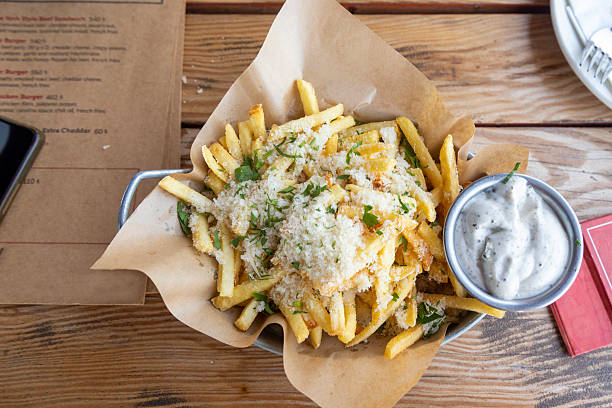 istock Crispy fries topped with cheese and herbs served in a casual dining setting 2232170945