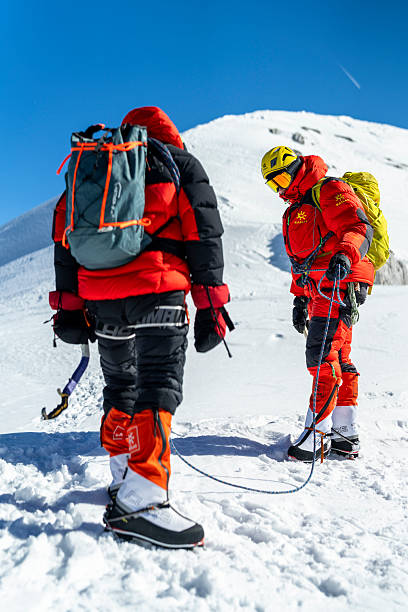 istock Professional Mountain Climbers Roped Together On Steep Snow Slope Under Clear Blue Sky 2232171976
