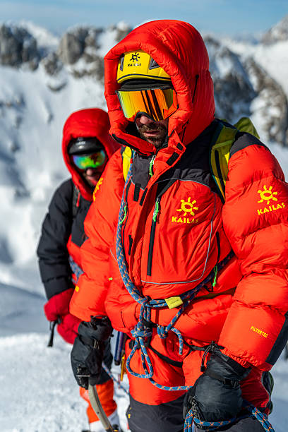 istock Professional Mountain Climbers In Bright Red Winter Gear On Snowy Alpine Summit 2232171990