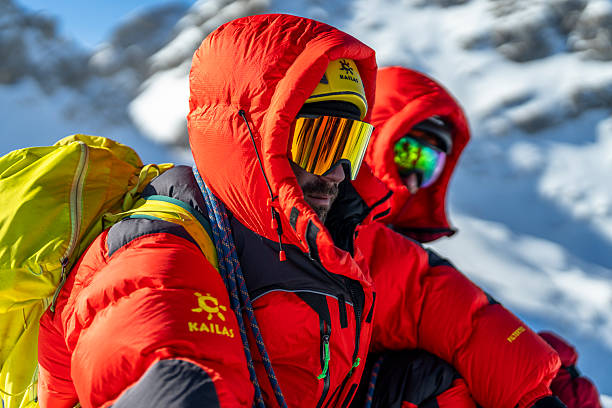 istock Smiling Mountaineers in Bright Red Climbing Gear on Snowy Mountain Summit 2232172003