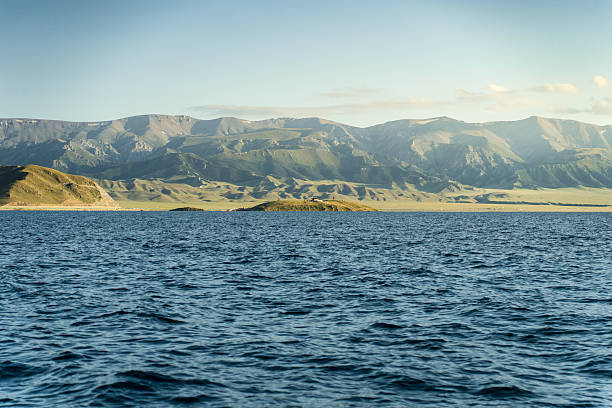 istock Grassland by the lake and distant mountains and blue sky 2232172975