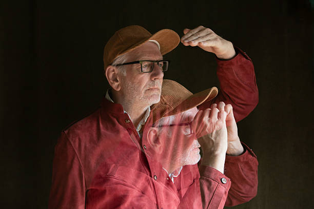 Elderly man as a digital twin looks into the distance, and pretending to look through binoculars
