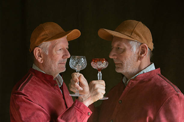 Classic music and wine. Young man wearing wig and vintage medieval outfit like famous composer, drinking green cocktail Contemporary art. Concept of eras comparison, creative pop art