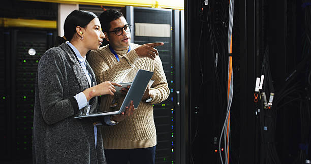 istock Datacenter, team and people with laptop for maintenance, software update or system inspection. Server room, collaboration or cloud computing with IT engineer for database, cybersecurity or discussion 2232174298