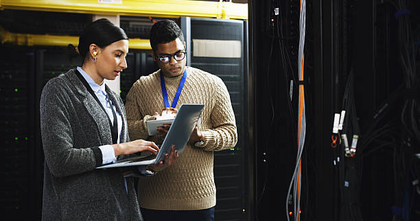 istock Server room, team and people with laptop for planning, software update or system maintenance. Datacenter, collaboration or cloud computing with IT technician for database or cybersecurity with tablet 2232174299