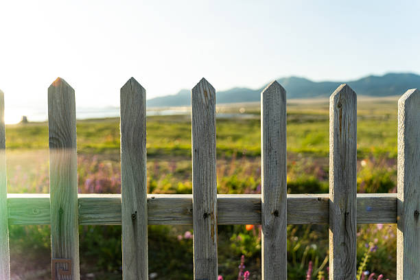 A brown wooden fence with the sea in the background