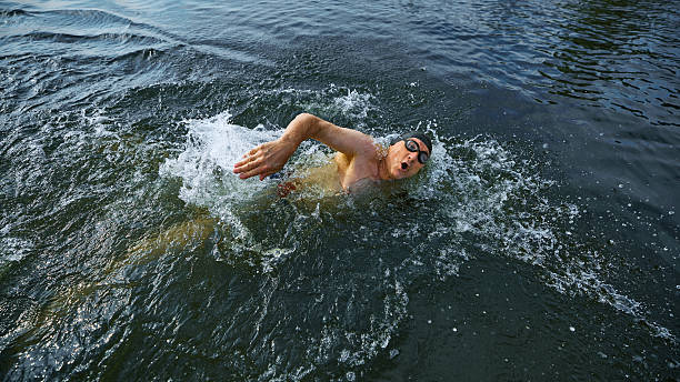 istock Middle-aged man swimming freestyle with energetic focus 2232176128