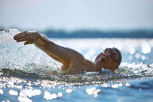 istock Older swimmer breathing mid-stroke with splash and emotion 2232176130