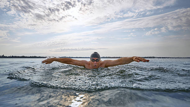 istock Mature swimmer performing butterfly stroke with intense focus 2232176134