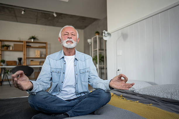 istock Senior man meditating in the lotus position on his bed 2232176362