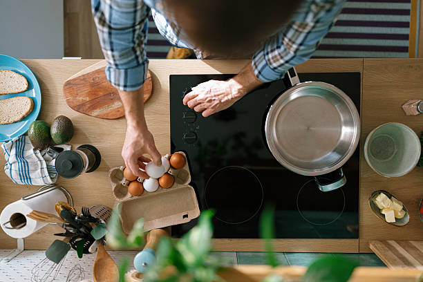 istock Top view of a man picking egg from carton box in kitchen 2232176764