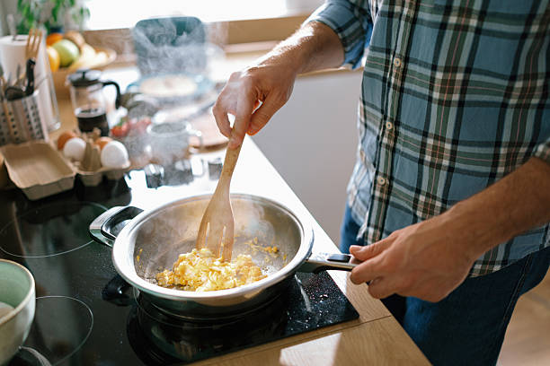 istock Man cooking omelette in frying pan at home 2232176829