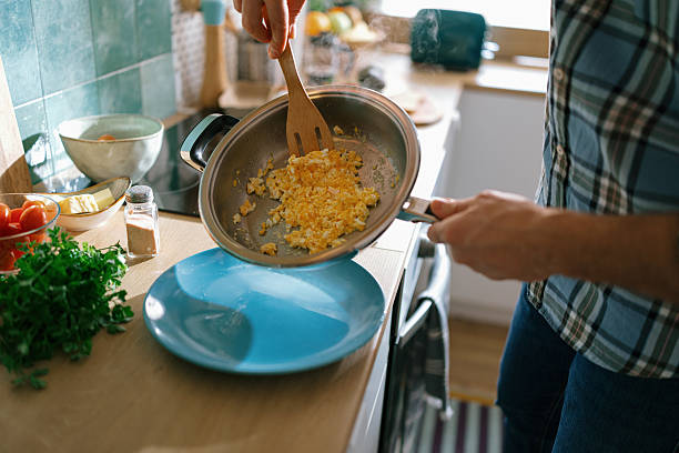 istock Man serving omelette from frying pan to plate 2232176885