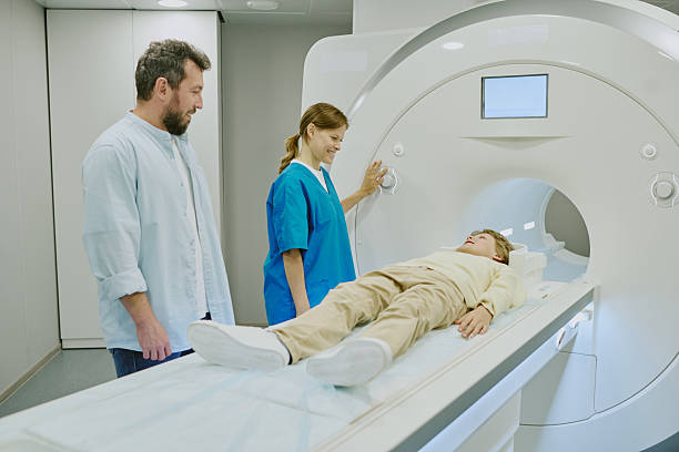 istock Caucasian Boy Lying in Mri Scanner While Female Technician and Man Assisting 2232178237