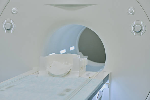 MRI scanner showing empty patient table positioned for medical imaging procedure, advanced diagnostic equipment used in hospital radiology department for body and brain scans