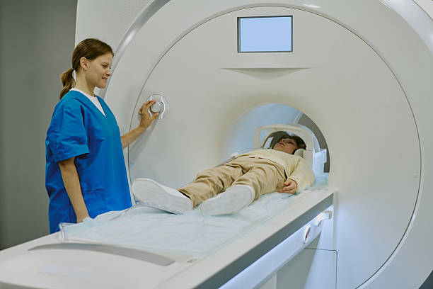 istock Caucasian Female Technician Operating Mri Scanner for Young Boy Patient 2232179299